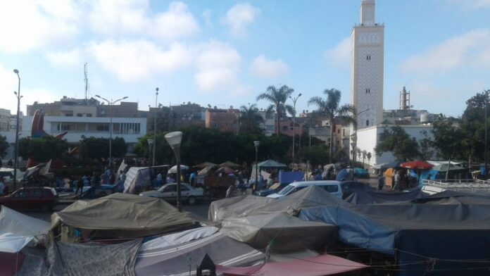 fotografia colori, esterno, mercato di Casablanca, Marocco, bancarelle con tende, automobili, sfondo edifici e palme