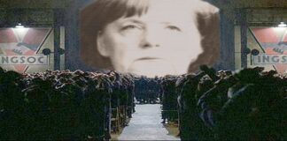Angela Merkel versione "1984" di Gerge Orwell, la sua faccia è proiettata sullo schermo davanti ai suoi sudditi.