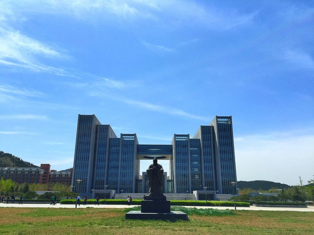 Photo of the statue of Confucius and a building in the background.