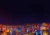 immagine digitale, colori, panorama di città con grattacieli a volo d'uccello, atmosfera notturna, cielo nero, luci colorate e sgargianti