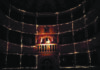 Scena al Teatro dei Coraggiosi, al centro l'attrice Giovanna Summo illuminata al centro su di una balconata