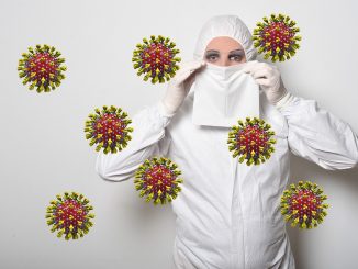 fotomontaggio, colori, riproduzioni ingigantite del coronavirus cinese viola e giallo, donna con tuta bianca anticontaminazione si tiene un fazzoletto bianco a coprire naso e bocca, sfondo bianco