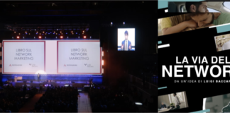 Presentazione del libro "La Via del Network" di Luigi Baccaro. Una foto mostra una sala piena di persone che assistono alla presentazione proiettata su un grande schermo centrale. Un primo piano dell’autore è mostrato su due schermi laterli più piccolo. A lato della foto, la copertina del libro