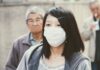 Image with an Asian girl wearing a white mask at to preserve herself from virus's attack.