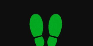 decoupling disaccoppiamento, concetto economico esemplificato da immagine di due impronte verdi di scarpe, sfondo nero