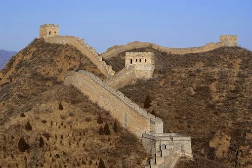 Mura di fortificazione intervallate da torri si inerpicano lungo un promontorio