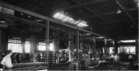 Fotografia degli anni 50 di una fonderia con operai al lavoro