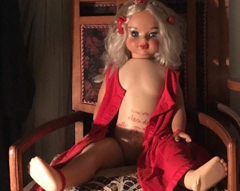 art dolls, love dolls, blond female doll with a red cape, sitting on a wooden chair