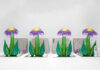 Quattro oggetti in plastica gonfiabile dalla forma di fiori con i petali viola sono disposti sopra quattro specchi