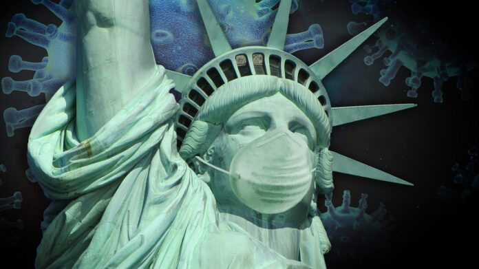 The virus of the pandemia that comes from China is on the background of the Statue of Liberty wearing a protective mask.