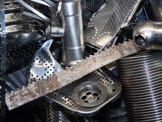 The photo shows several metal scraps, including a sawtoothed blade, a pipe, a pedal and a sink pipe union