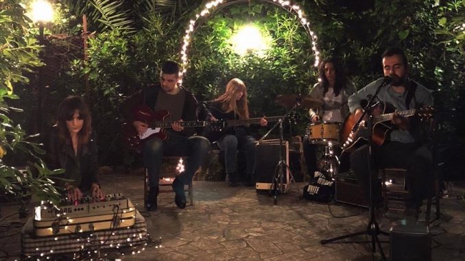 la band Portnoy sta suonando in un giardino illuminato da tante piccole luci da esterno