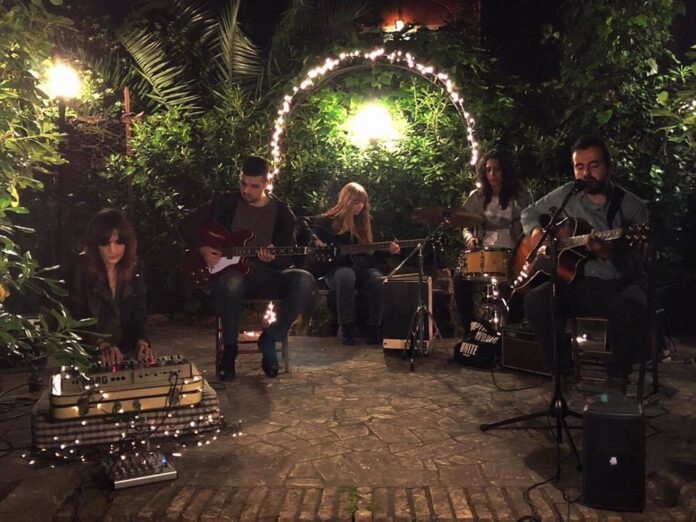 la band Portnoy sta suonando in un giardino illuminato da tante piccole luci da esterno