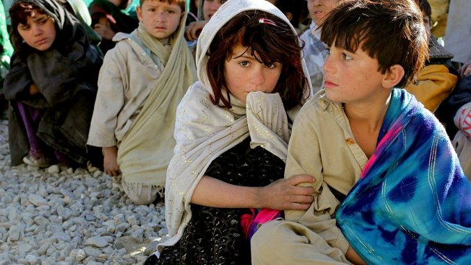 Economy after covid, picture of children sitting on the ground in a poor area of the world