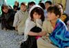 Andrà tutto bene alla fine di questa pandemia?, foto a colori di bambini seduti per terra in area povera del mondo