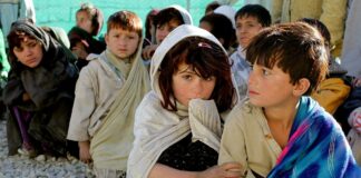 Andrà tutto bene alla fine di questa pandemia?, foto a colori di bambini seduti per terra in area povera del mondo