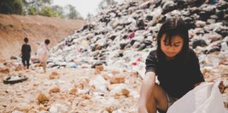 World hunger: permanent emergencies, asian girl scattering in a dumpsite