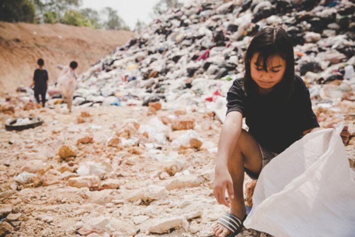 World hunger: permanent emergencies, asian girl scattering in a dumpsite