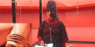 Bondage art, performance by Vitaldo Conte, girl tied to a chair, red background