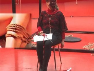 Arte Bondage, foto di performance artistica con donna legata su sedia, sfondo rosso
