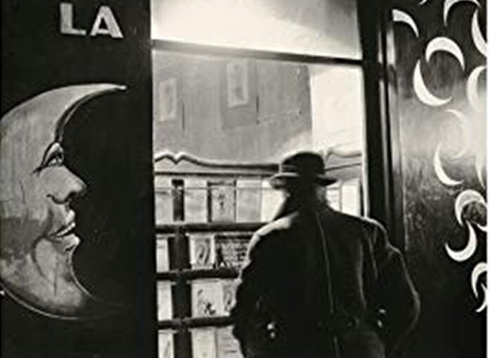 Parigi letteraria, foto bianco e nero, uomo di spalle davanti a vetrina