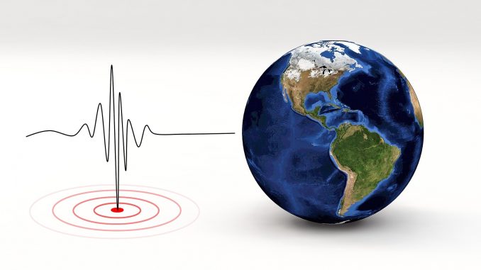 earthquake-pandemic nella foto a colori si vede a destra un mappamondo e a sinistra un grafico elettrocardiogramma
