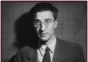 Black and white photo of Cesare Pavese, half body, suit and tie on dark background