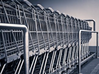 foto in scala di grigi di un fila di carrelli del supermercato