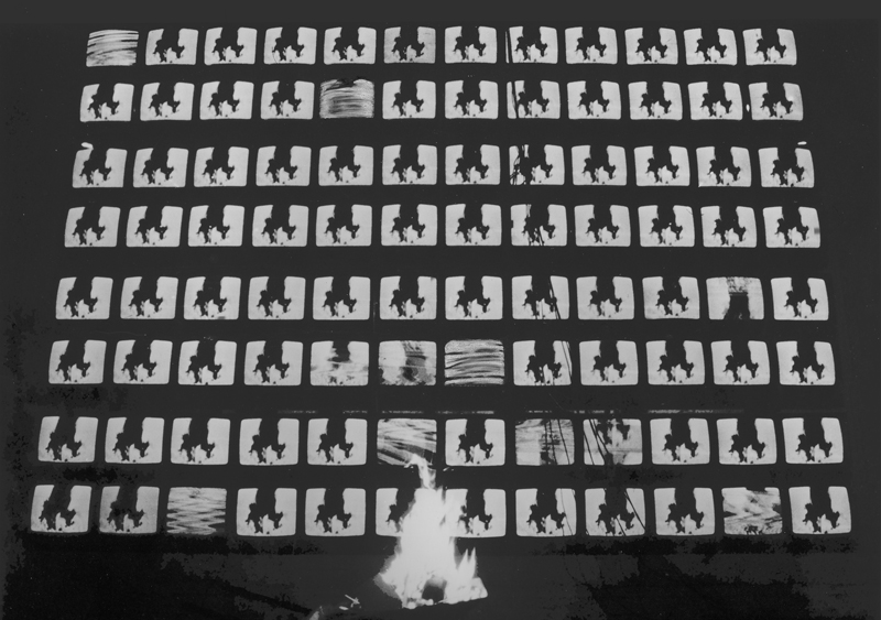Opera di Federico De Leonardis composta da cento monitor in un quadrato 10x10 e una carriola che va a fuoco.