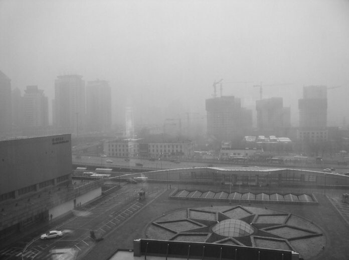 black and white photo of a city enveloped in fog