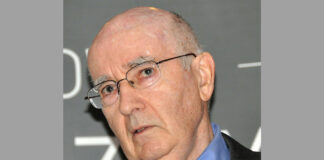 nella foto si vede il Professor Philip Kotler, un signore anziano che indossa occhiali, una cravatta rossa e una camicia celeste