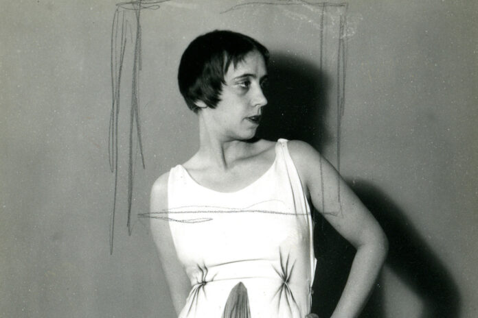 nella foto in bianco e nero si vede la stilista Elsa Schiaparelli di profilo, con i capelli a caschetto e un abito estivo a maniche corte