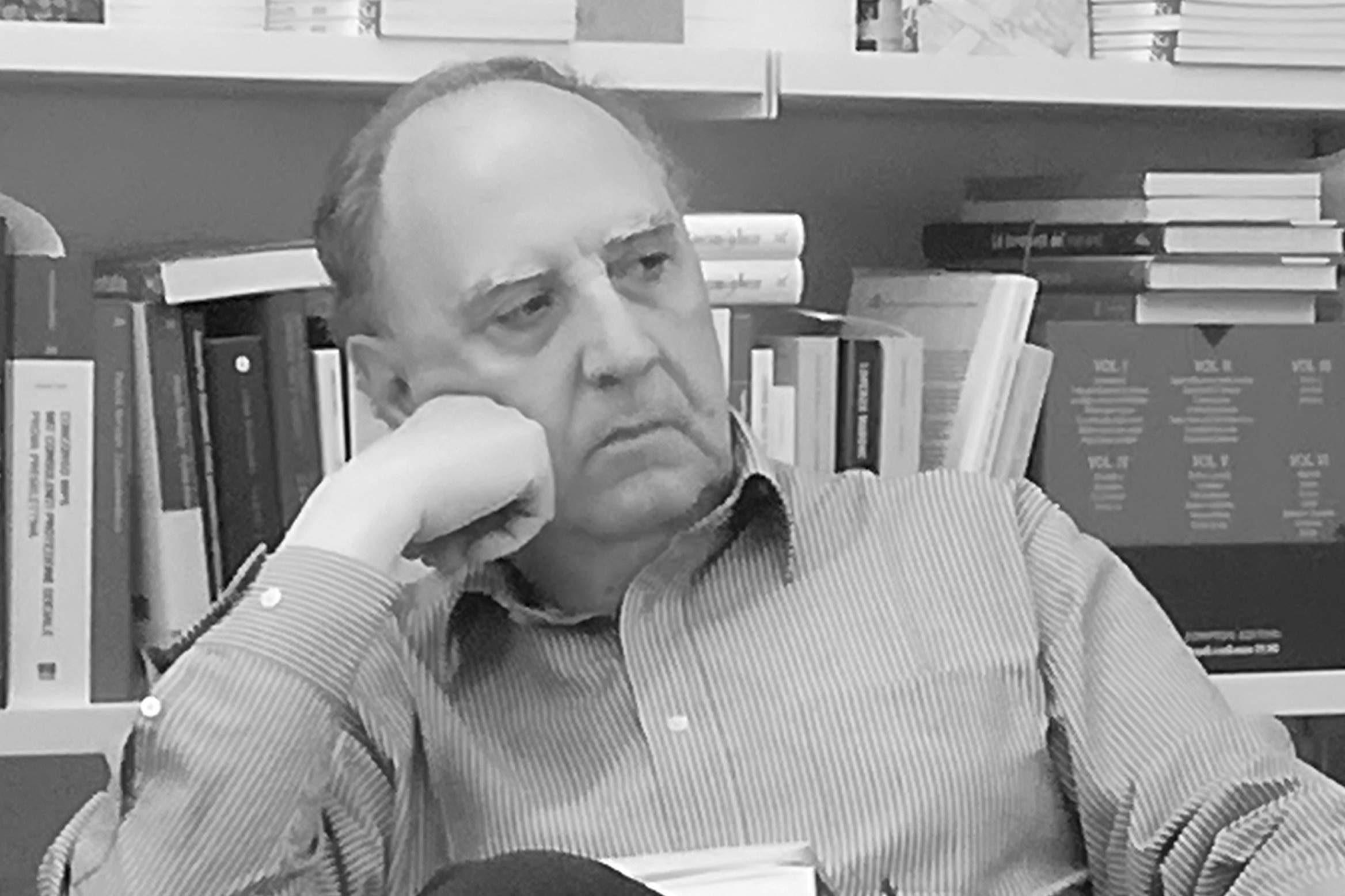 in the black and white photo you can see an elderly man wearing a striped shirt, with his right hand resting on his right cheek
