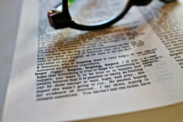 in the color photo you can see an English newspaper and above it a pair of black-rimmed glasses