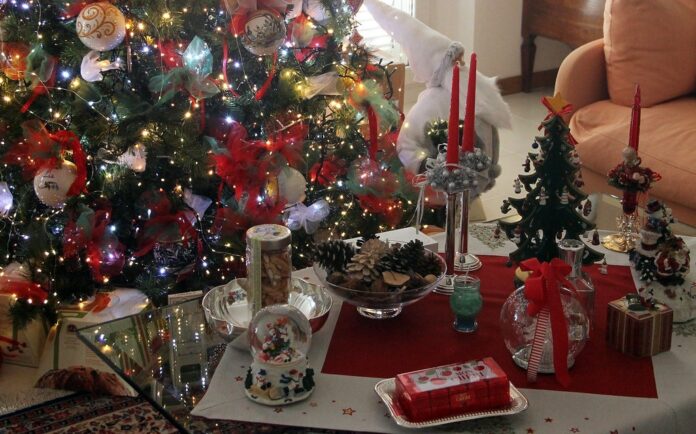 nella fotografia: un albero di Natale, candele rosse, soprammobili natalizi, cioccolatini, pacchetti dono, pigne, sono i simboli del Natale italiano.