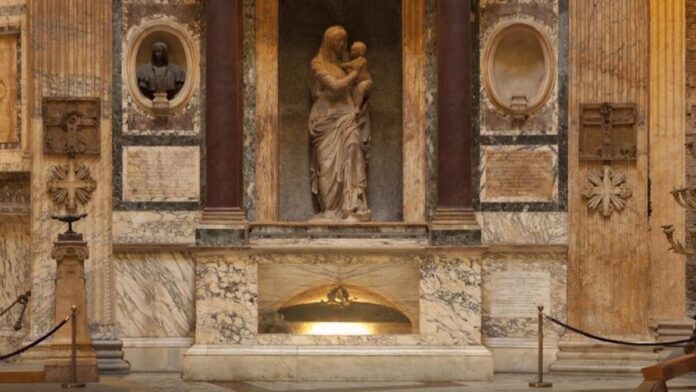 fotografia della tomba marmorea di Raffaello Sanzio in Roma al Pantheon sormontata la scultura in marmo chiaro de La Madonna del Sasso opera di Lorenzetto allievo del maestro
