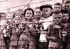 in the black and white image you can see children locked up in a Nazi concentration camp, leaning on a barbed wire