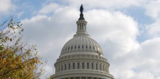 nella fotog: a Capitol Hill, la cupola del parlamento americano a Washington con la bandiera americana che sventola