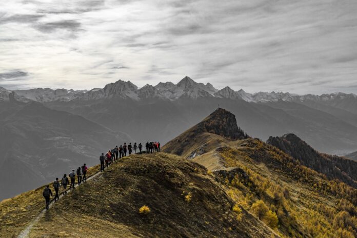 su un sentiero di montagna un gruppo di persone cammina in fila indiana