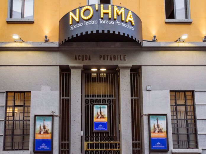 L'esterno dello Spazio Teatro No'hma di Milano dove campeggiano l'insegna, appena sotto la scritta Acqua Potabile e il cancello d'entrata -chuso- con tre locandine