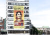 nella foto a colori si vede un edificio sul quale è stato affisso un poster di Amnesty International con l'immagine della leader Aung San Suu Kyi