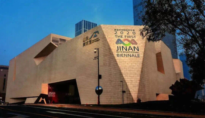 nella foto a colori si vede la sede della Biennale di Jinan 2020, un moderno edificio marrone.