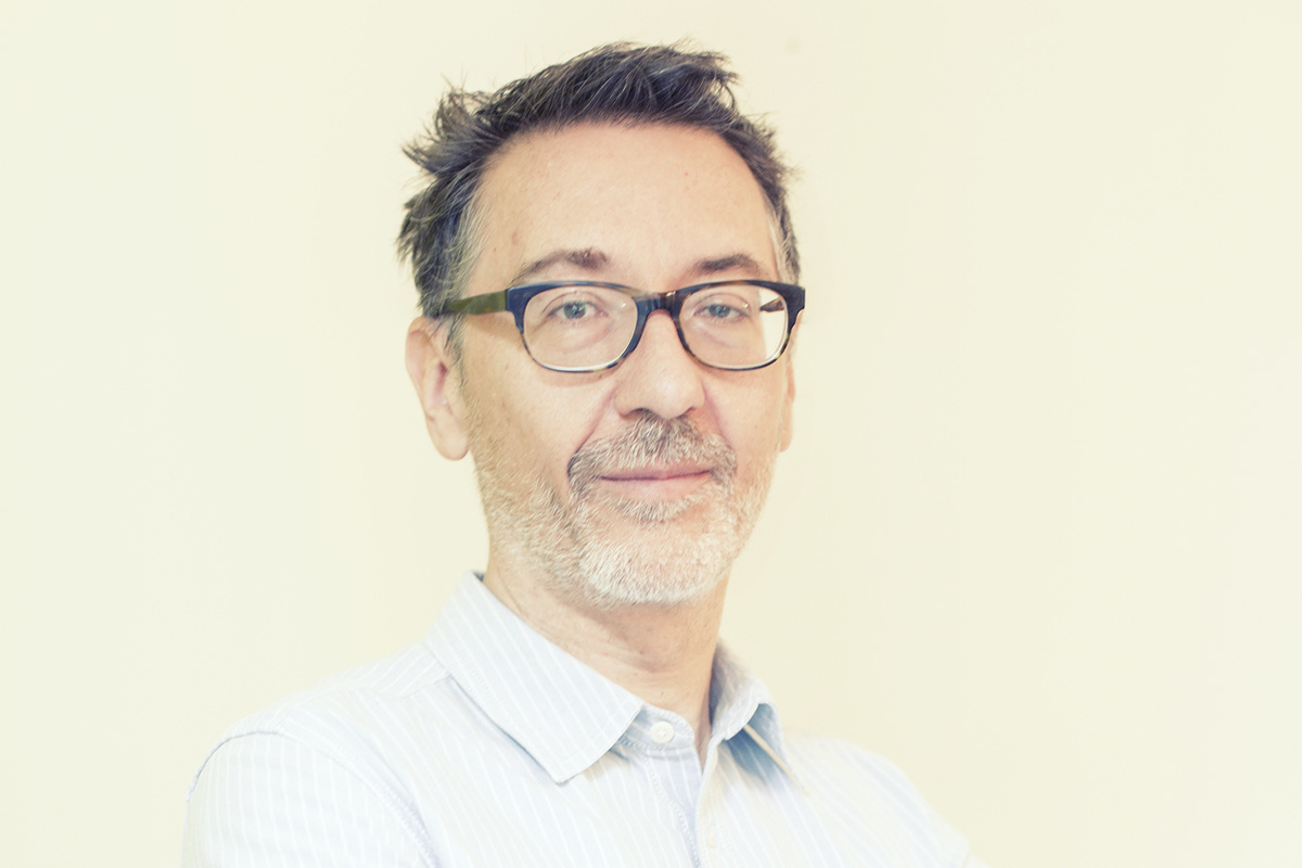Fintech, banche e imprese – Banks and companies nella foto a colori si vede l'amministratore delegato di Workinvoice, Matteo Tarroni, che indossa occhaili neri e una camcia chiara a righe bianche. Ha un accenno di barba.