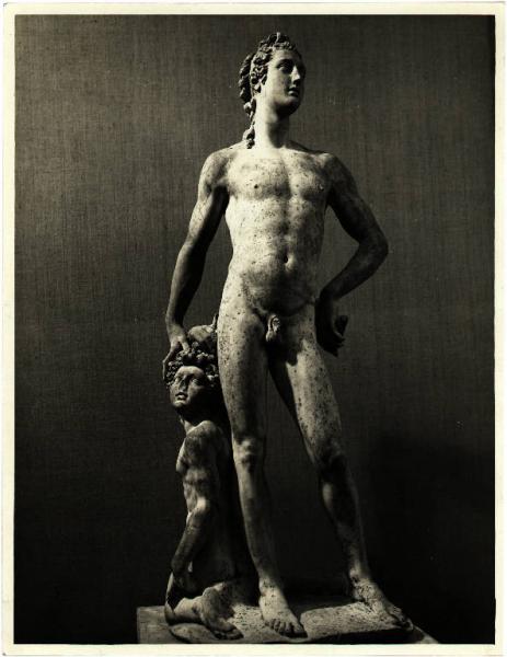 Scultura classica che rappresenta un uomo in piedi, nudo, la cui mano destra è poggiata sul capo di un giovane nudo inginocchiato, di lato, in senso opposto, che guarda nel senso dell'uomo in piedi