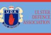 L'immagine mostra il logo della Ulster Defence Association, una mano rossa alzata su uno scudo blu contornato di bianco con una corona e la sigla UDA sopra ed il motto "Quis Separabit" sotto
