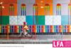 The London Festival of Architecture London Festival of Architecture, the poster: a colorful wall, a boardwalk with a baby boy on a bicycle, a colorful protective railing