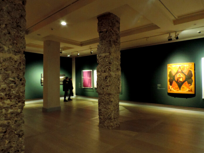 Veduta angolare di una galleria d'arte con opere contemporanee di fianco a icone russe antiche
