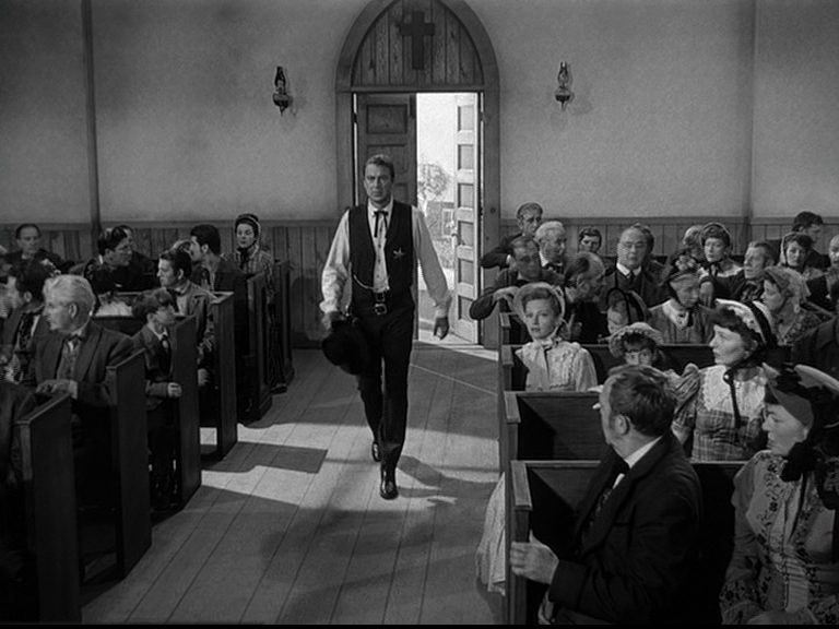 lo spezzone del film "Mezzogiorno di fuoco", in bianco e nero ritrae un gruppo di fedeli in una chiesa con al centro, lo sceriffo che entra