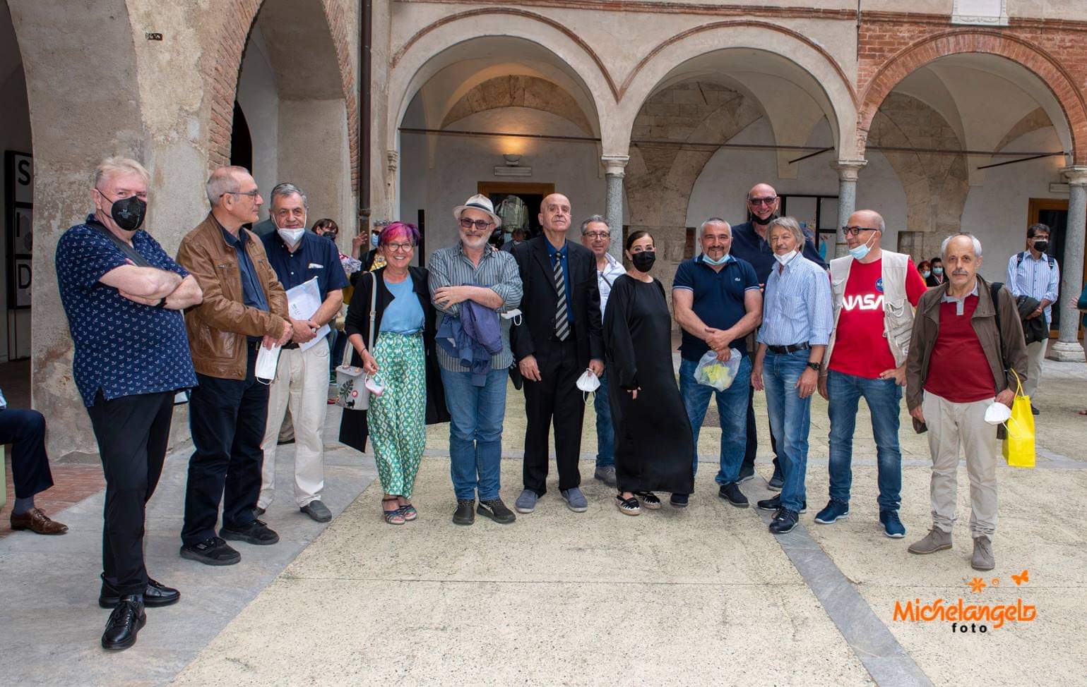 gruppo di persone disposte a ferro di cavallo all'interno di un chiostro