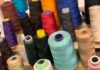 Rocchetti di filo per macchina per cucire di vari colori, all'interno del laboratorio dell'Associazione Spazio3R